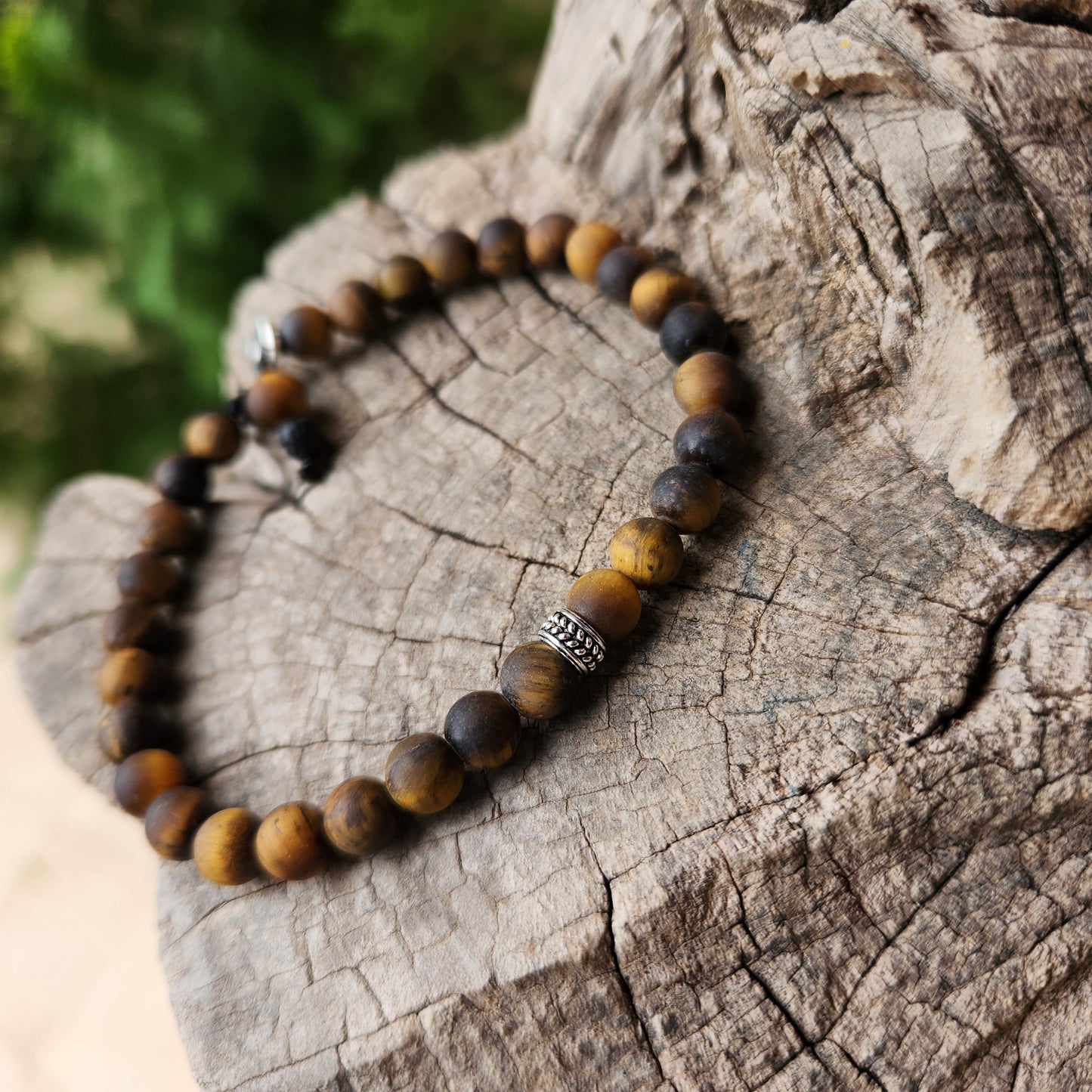 Beaded bracelet on a wooden surface with a blurred green background