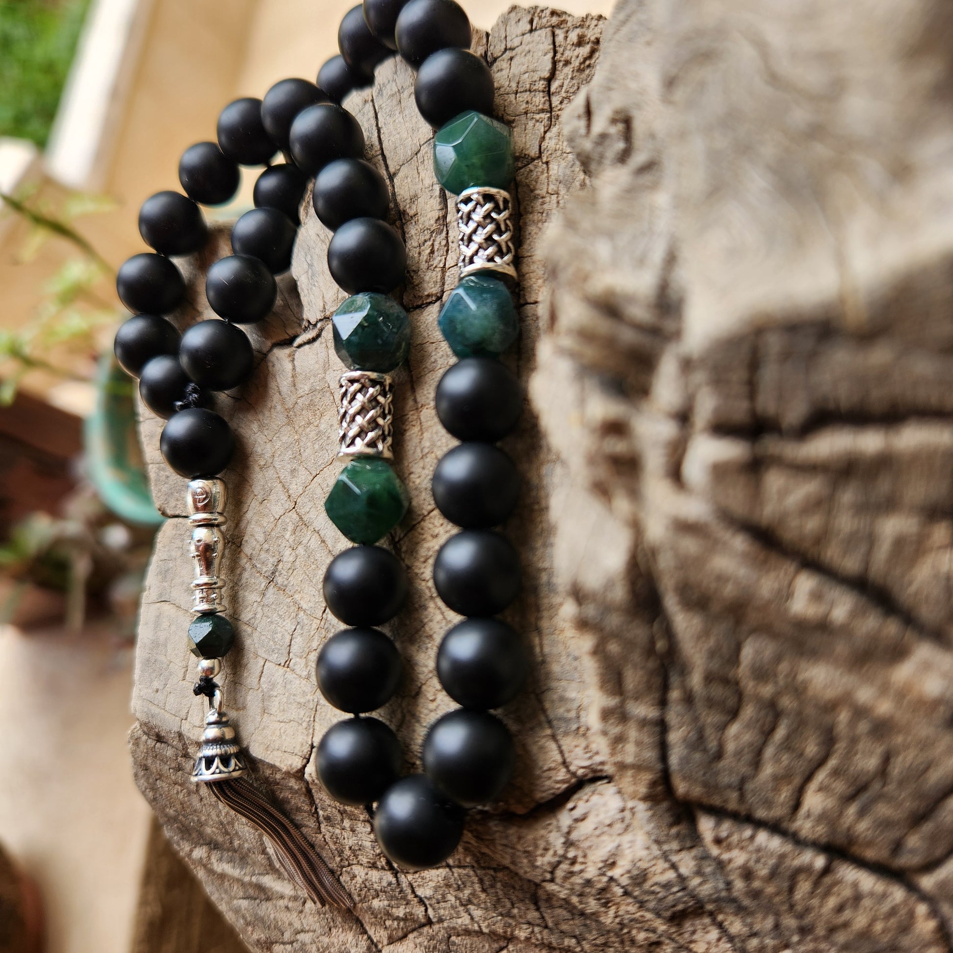 Black and green beaded misbaha on a wooden surface