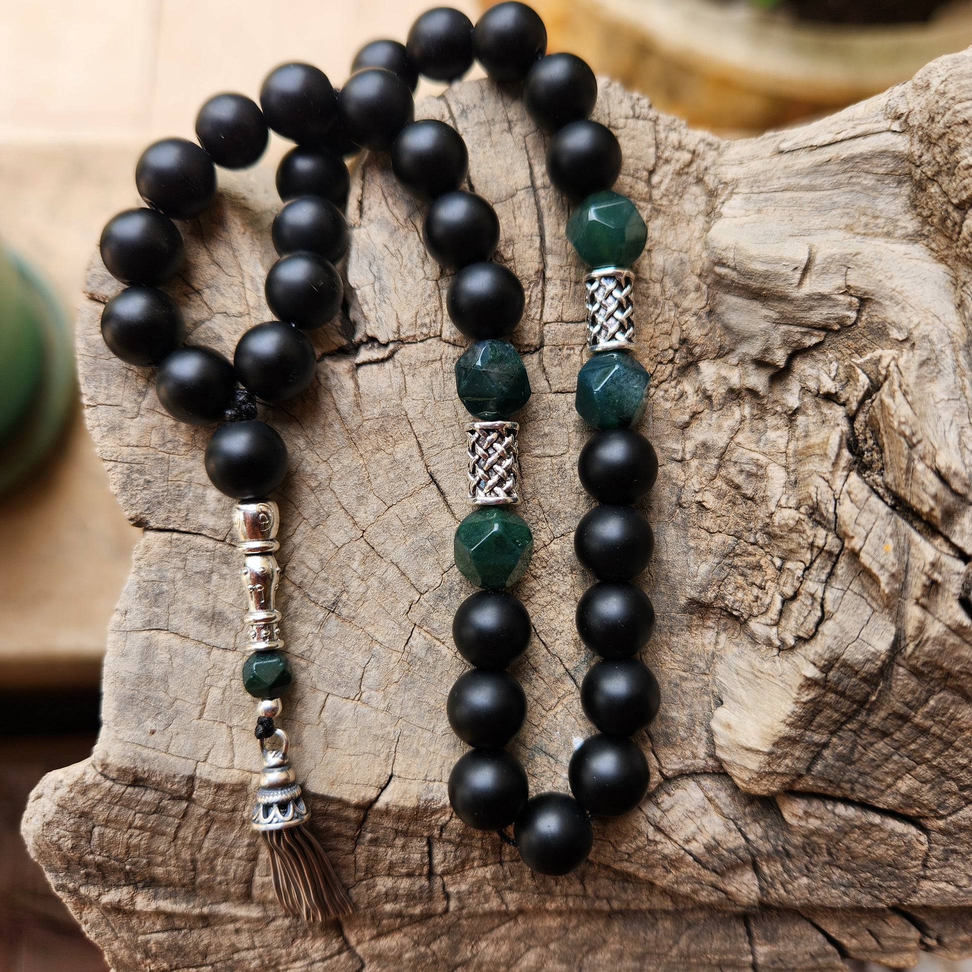 Black and green beaded misbaha on a wooden surface