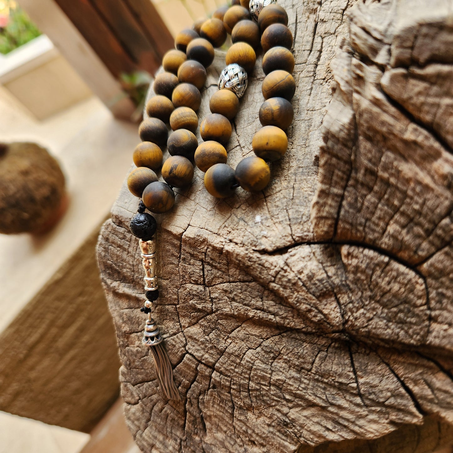 Wooden like beaded misbaha with tassel on a wooden surface