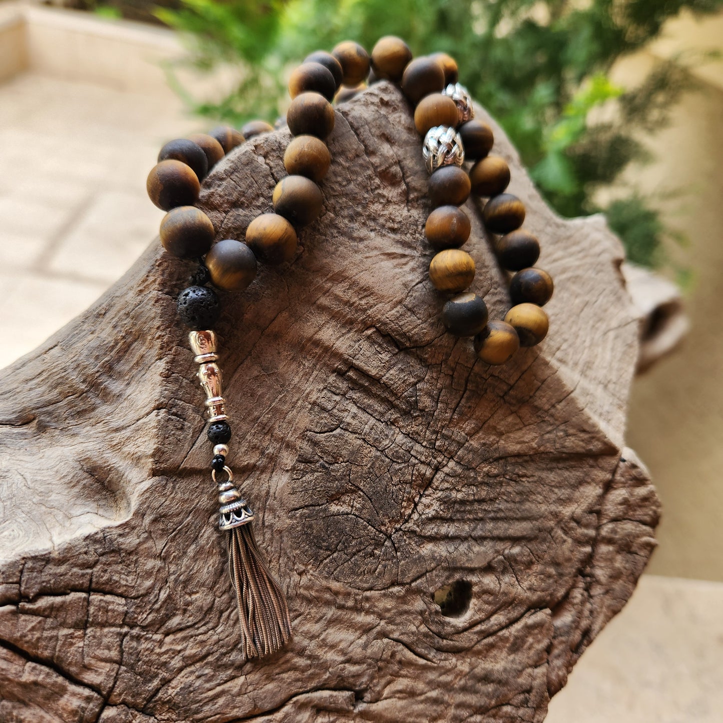Wooden like beaded misbaha with tassel on a wooden surface
