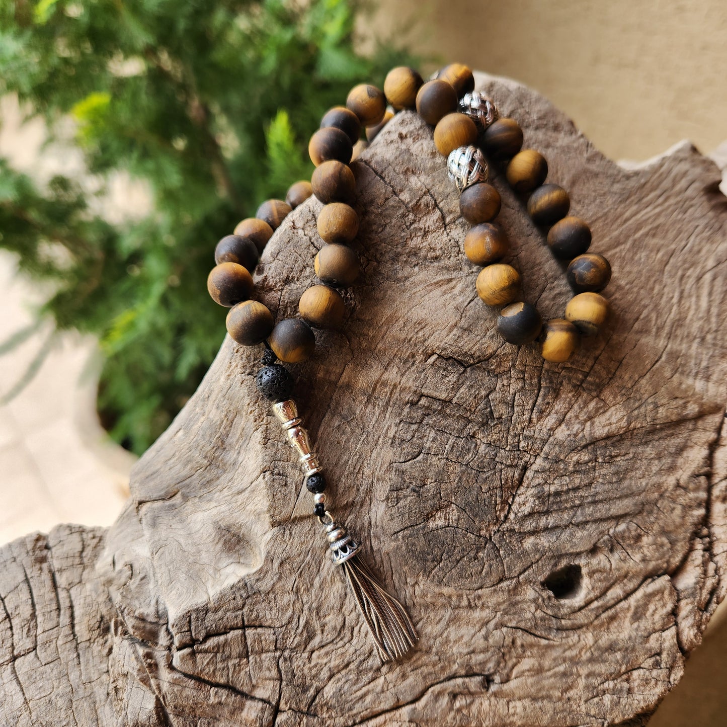 Wooden like beaded misbaha with tassel on a wooden surface