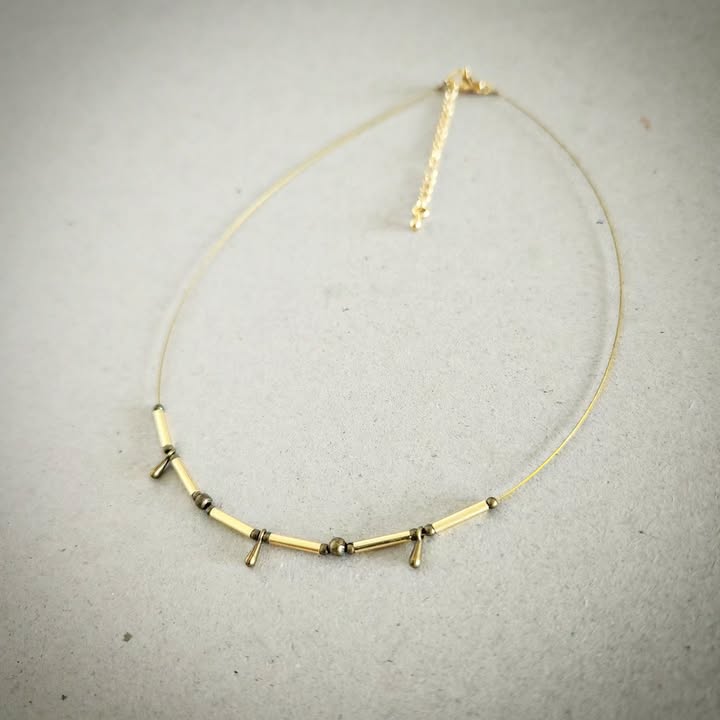 Necklace with gold and bronze beads on a gray background