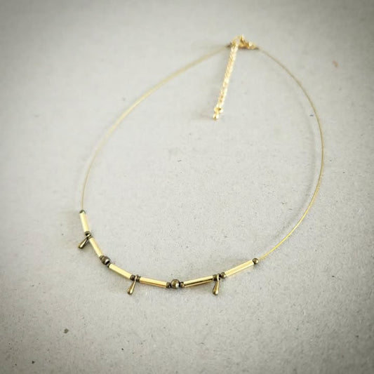 Necklace with gold and bronze beads on a gray background
