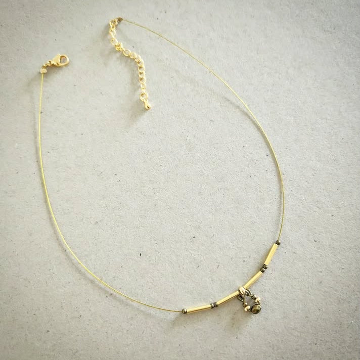 Necklace with gold and bronze beads on a gray background