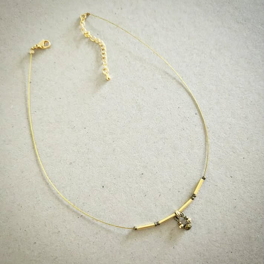 Necklace with gold and bronze beads on a gray background