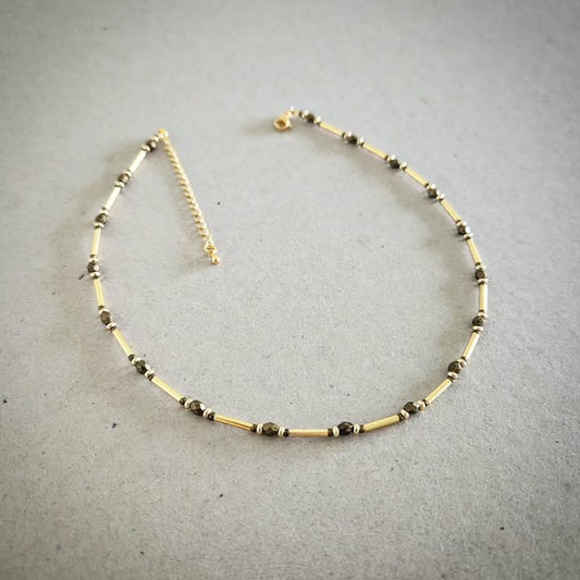 Necklace with gold and bronze beads on a gray background