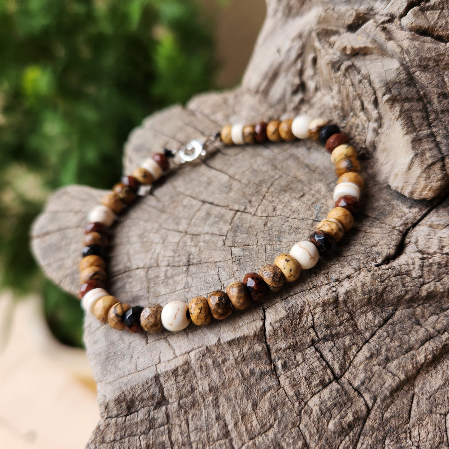 Beaded bracelet on a wooden surface with a blurred green background