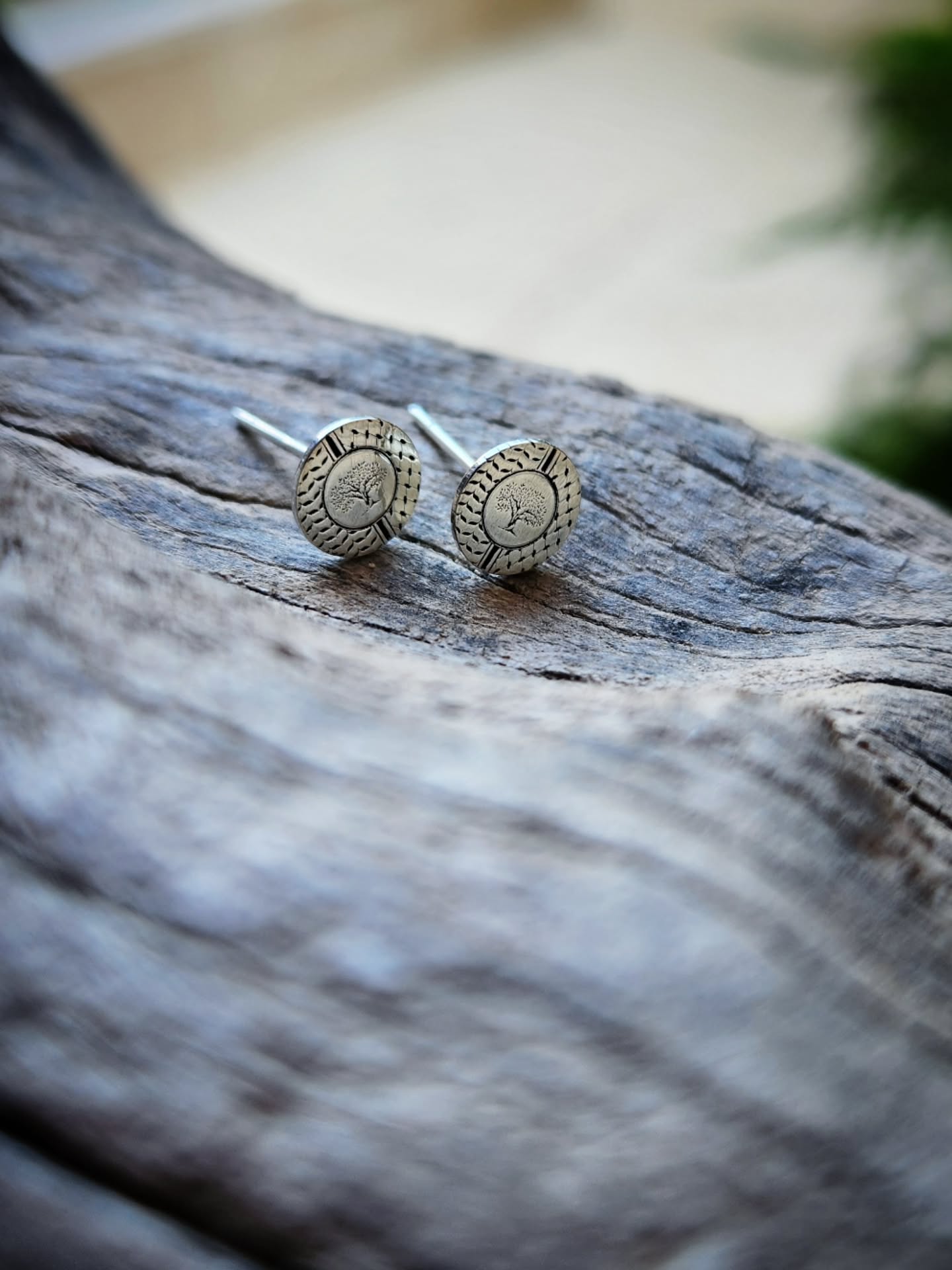 Silver stud earrings on a wooden surface