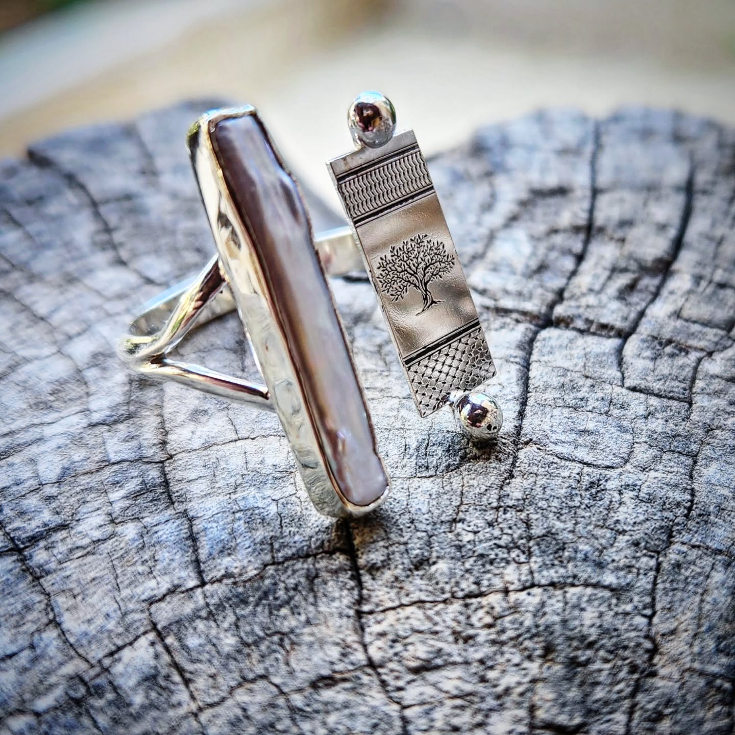 Silver ring with a tree design and a pearls on a wooden surface