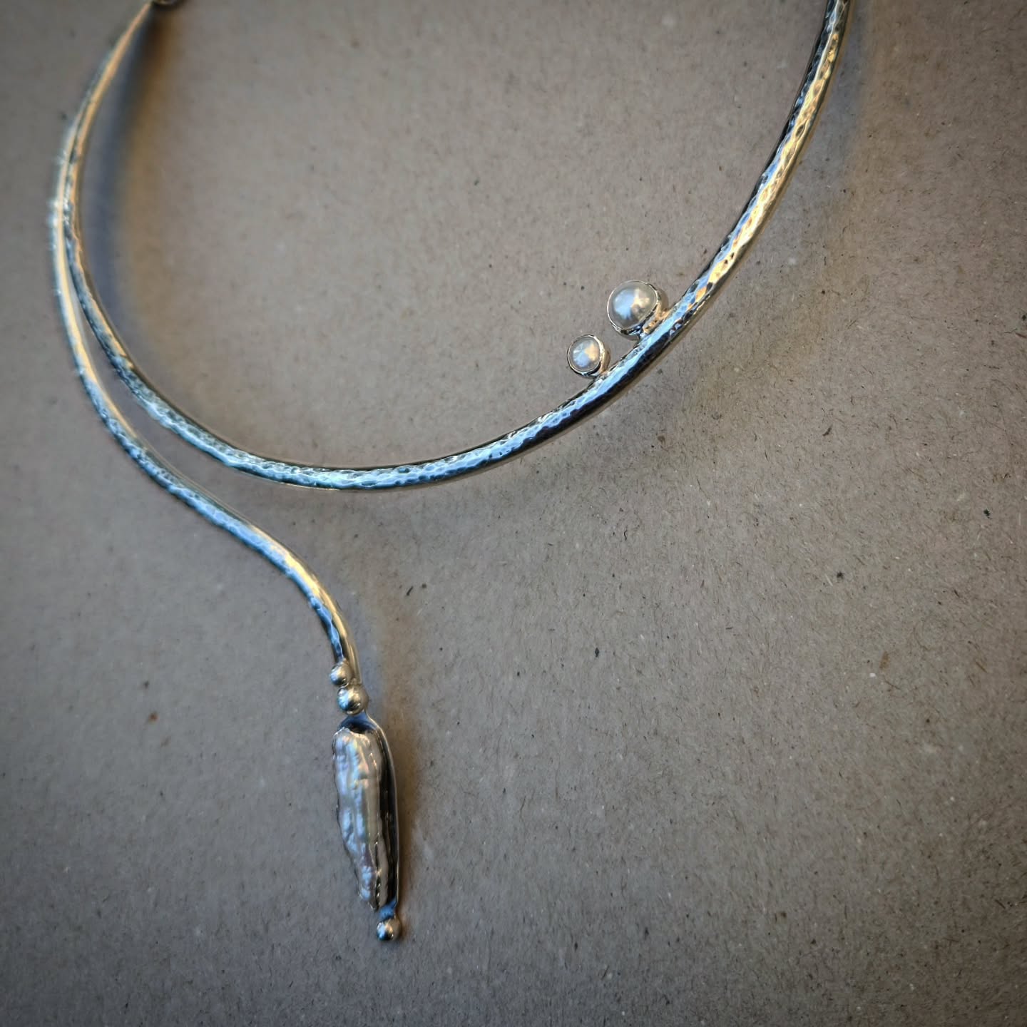 unique handmade silver necklace with pearls on a gray background