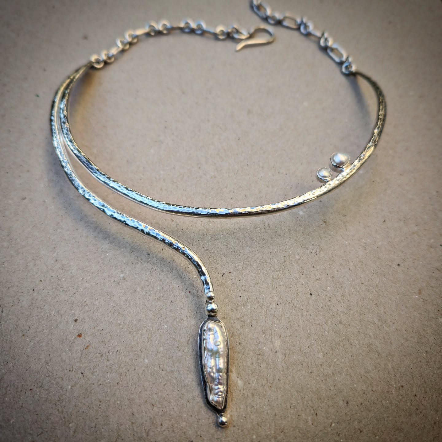 unique handmade silver necklace with pearls on a gray background