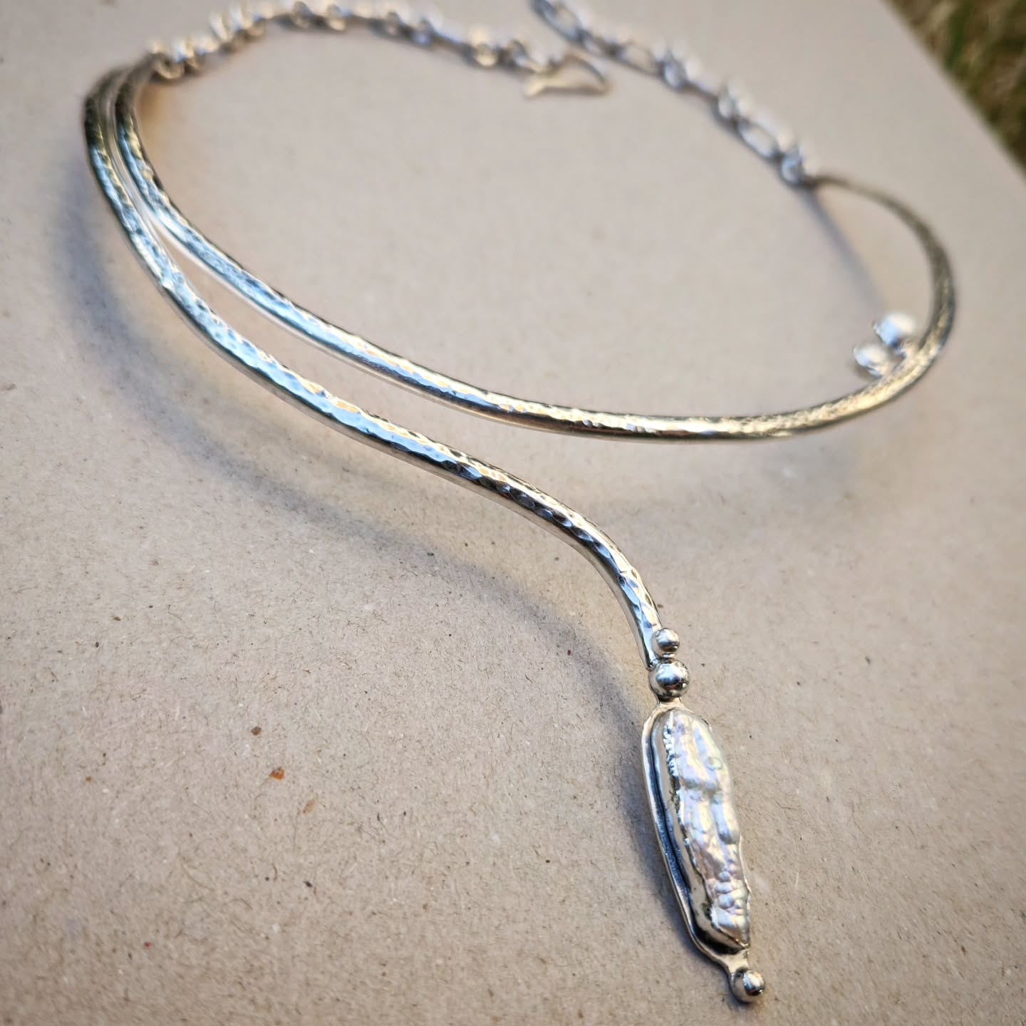 unique handmade silver necklace with pearls on a gray background