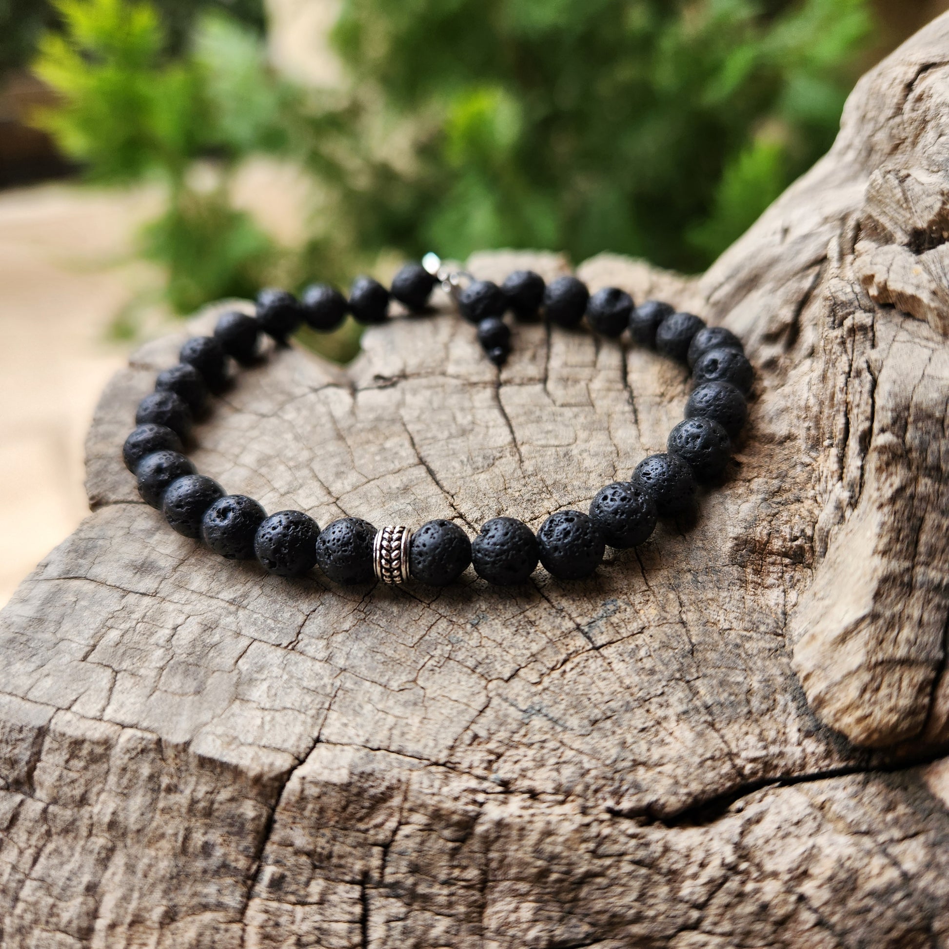 Black beaded bracelet on a wooden surface with a natural background