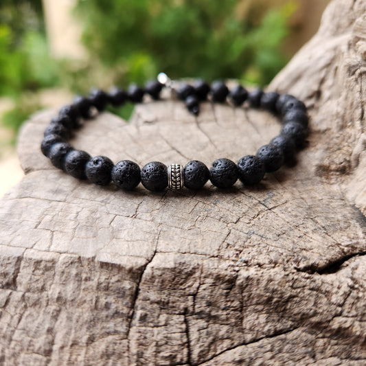 Beaded bracelet on a wooden surface with a blurred green background
