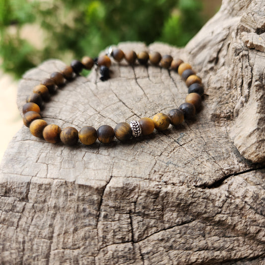 Beaded bracelet on a wooden surface with a blurred green background