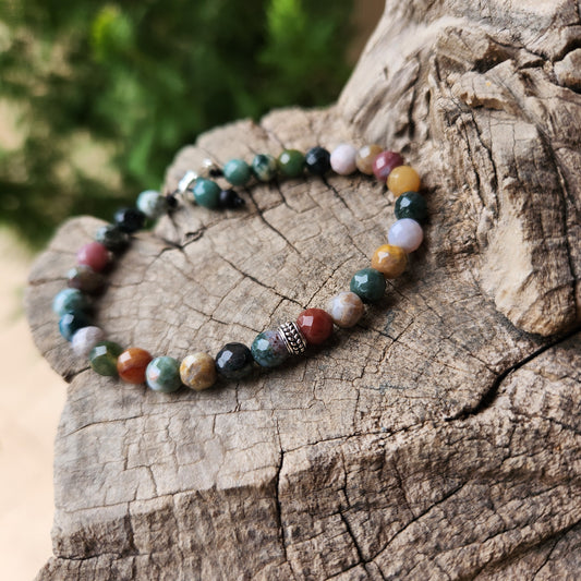 Beaded bracelet on a wooden surface with a blurred green background