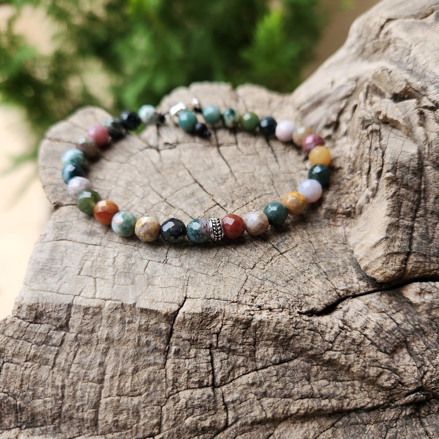 Multicolored beaded bracelet on a wooden surface with a natural background
